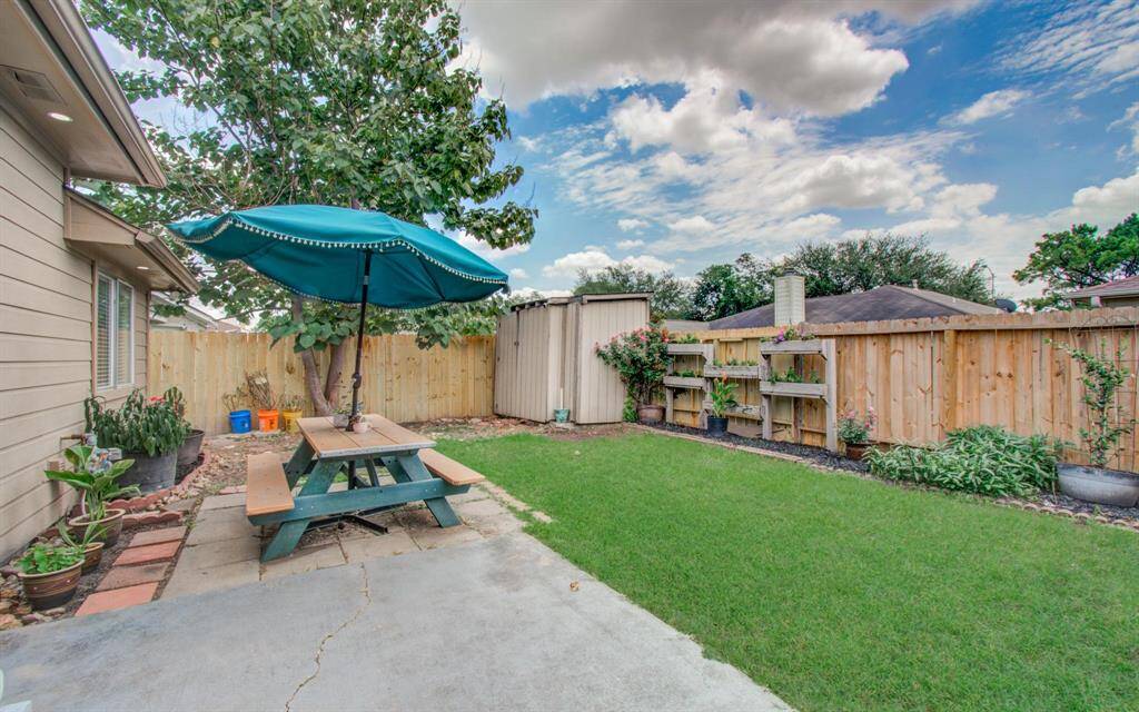 Garden-ready yard, Storage shed, tiered planter shelves and sunny green lawn ideal for pets, play and home-grown herbs.