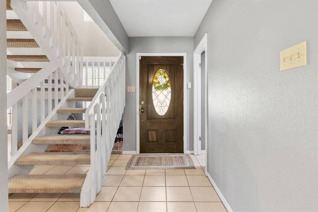 Entry to the home featuring open staircase.