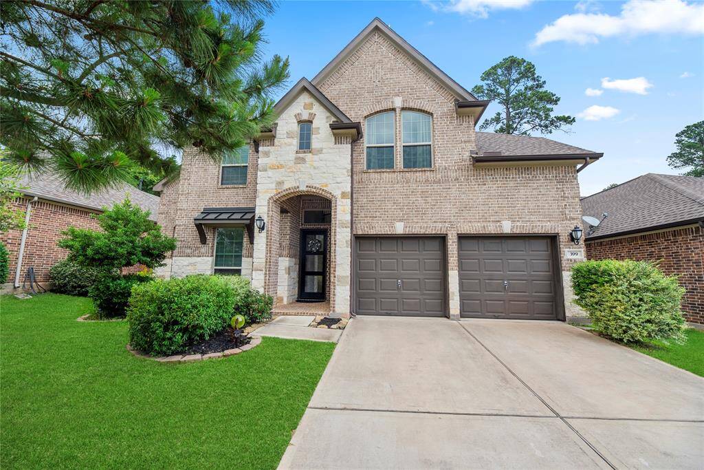 Impressive Two-Story Exterior: This elegant brick and stone home offers a stately presence, double driveway, two-car garage, and mature landscaping on a quiet, tree-lined street.