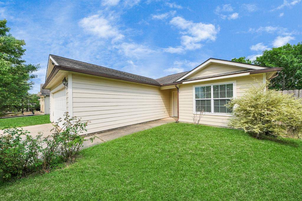 Charming single-story home with a clean, well-kept exterior and attached garage. The front yard is spacious with lush green grass and mature trees, offering great curb appeal.