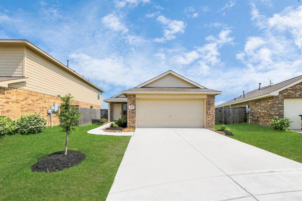 Charming single-story brick home with a two-car garage, well-maintained front lawn, and a welcoming path. Perfect for a cozy family living.