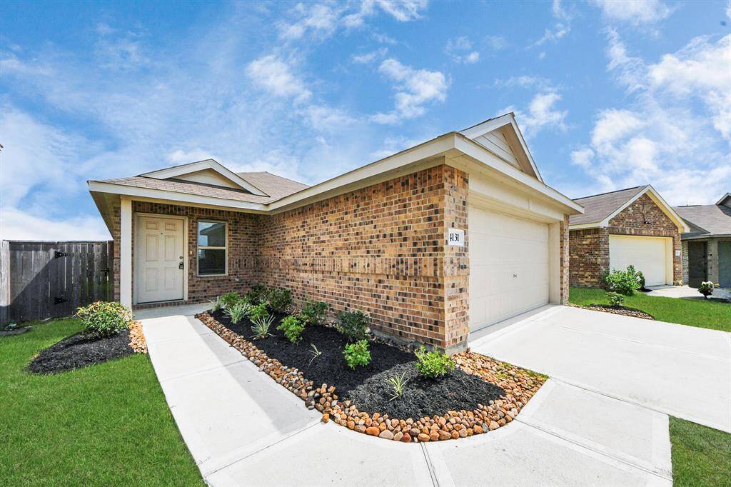 This is a charming single-story brick home with a two-car garage. The exterior features a well-maintained lawn, neat landscaping, and a welcoming front entry. The driveway and walkway are paved, leading to a cozy front porch.