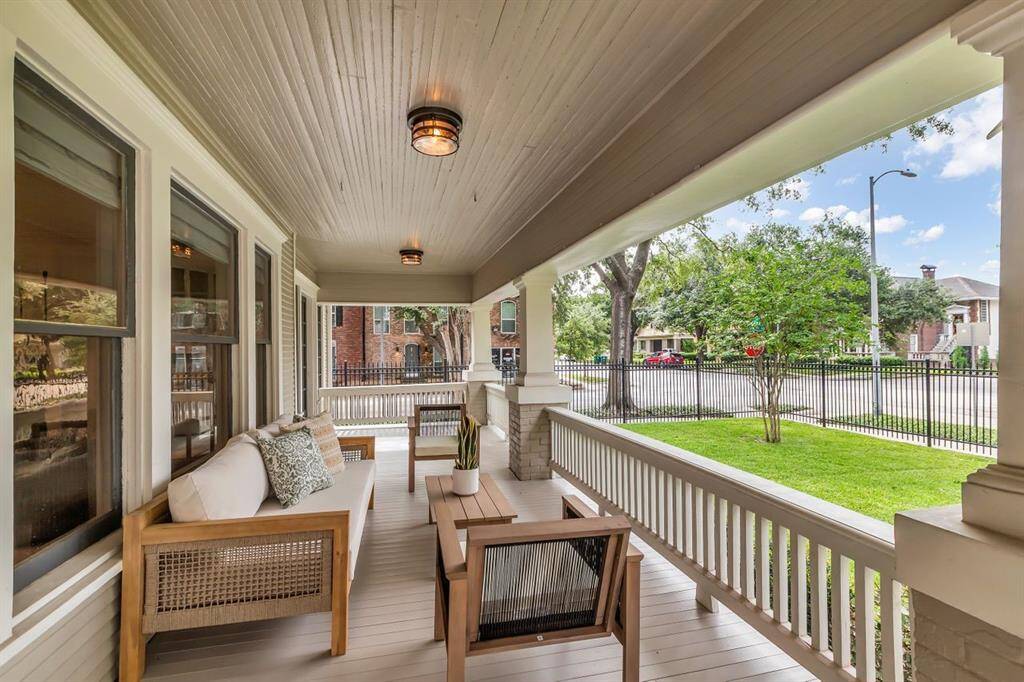 Expansive front porch features original details including brick Craftsman columns. and tongue and groove plank wood accents.