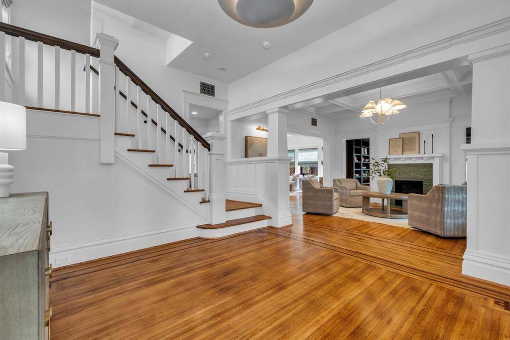 Spacious entry features original oak flooring with mahogany accents which continue throughout the house. Classic Craftsman details include a paneled pony wall accented with wood columns are all original to the property.