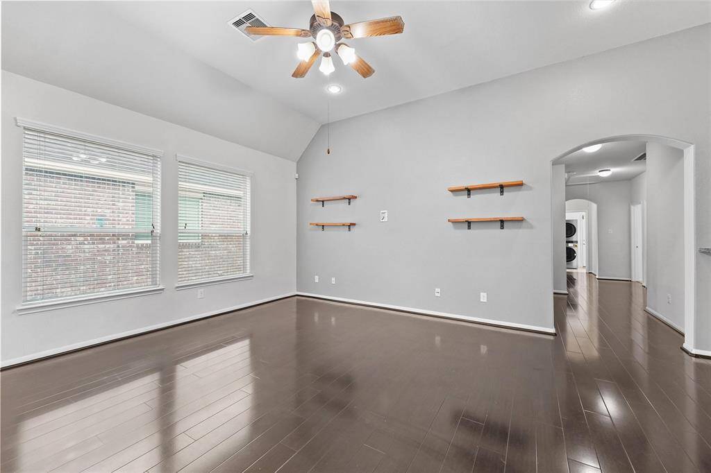 Cozy up in this spacious living room with rich flooring, built-in shelves, and tons of natural light.