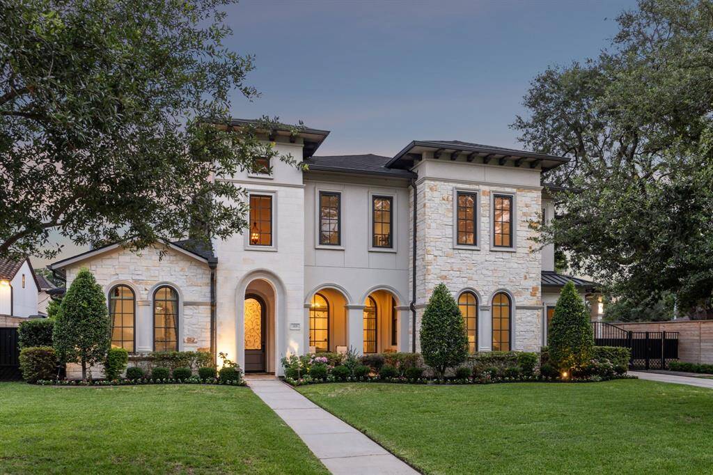 Welcome to 5659 Willers Way! This beautiful home features a modern exterior with a blend of stone and stucco, accented by elegant arched windows.