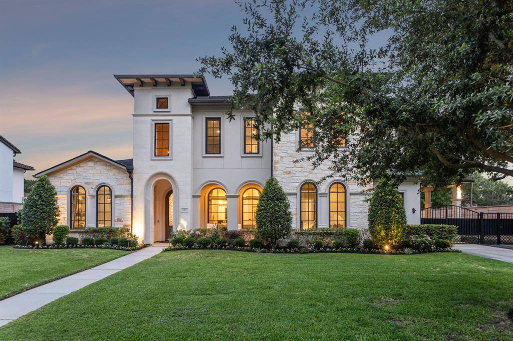 The well-mainted front lawn is lined with mature shrubs and trees, offering both privacy and curb appeal.