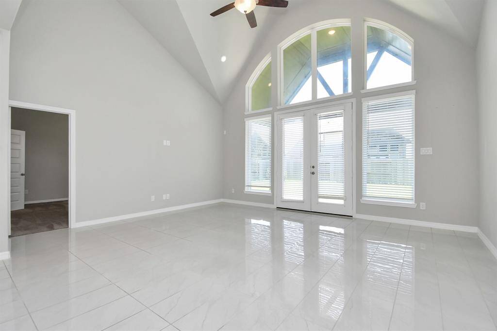 The spacious living area is a true showstopper, featuring a stunning wall of windows that floods the space with natural light and offers picturesque views of the surrounding greenery.