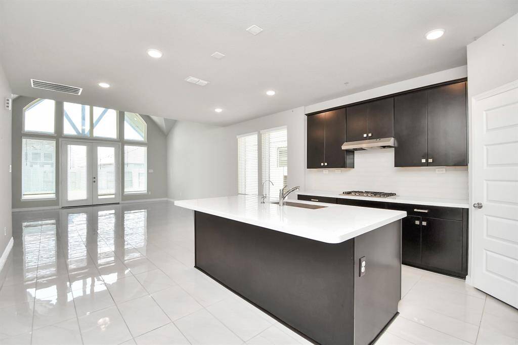 The dark cabinetry provides a rich, luxurious feel, while the white solid surface countertops add a touch of contemporary flair.