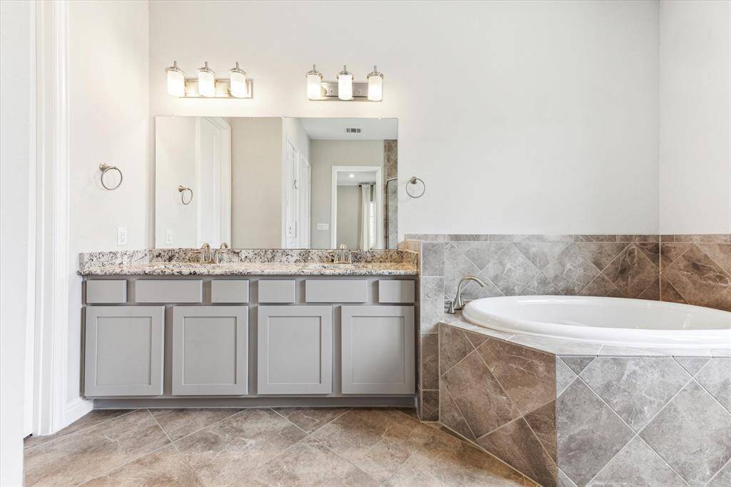 The primary bath has granite topped vanity with two sinks, a separate water closet and abundant storage.