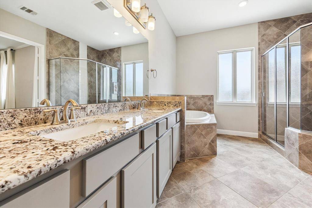 Soaking tub on the left and oversized shower with bench on the right.  Note the natural light that streams in through the window.