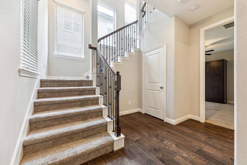 The entry welcomes you with gleaming wood floors and natural light.  One of the two secondary bedrooms with en-suite bath can be seen through the doorway on the right.  The door under the stairs is to the wraparound closet under the stairs that offers exceptional storage.
