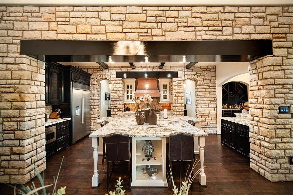 Custom stone work & beams appoint the kitchen.