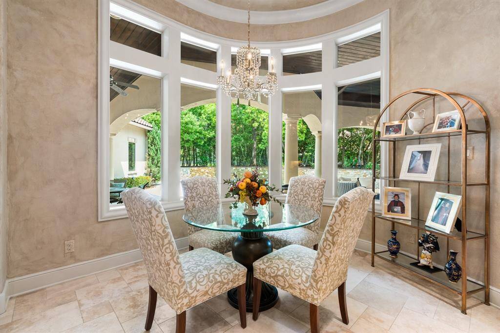The breakfast nook offers large windows providing views of the pool and a private, tree-lined backdrop overlooking the golf course.