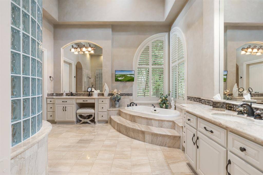 Light, bright and boasting every comfort, the primary bath features his & her vanities with generous storage.