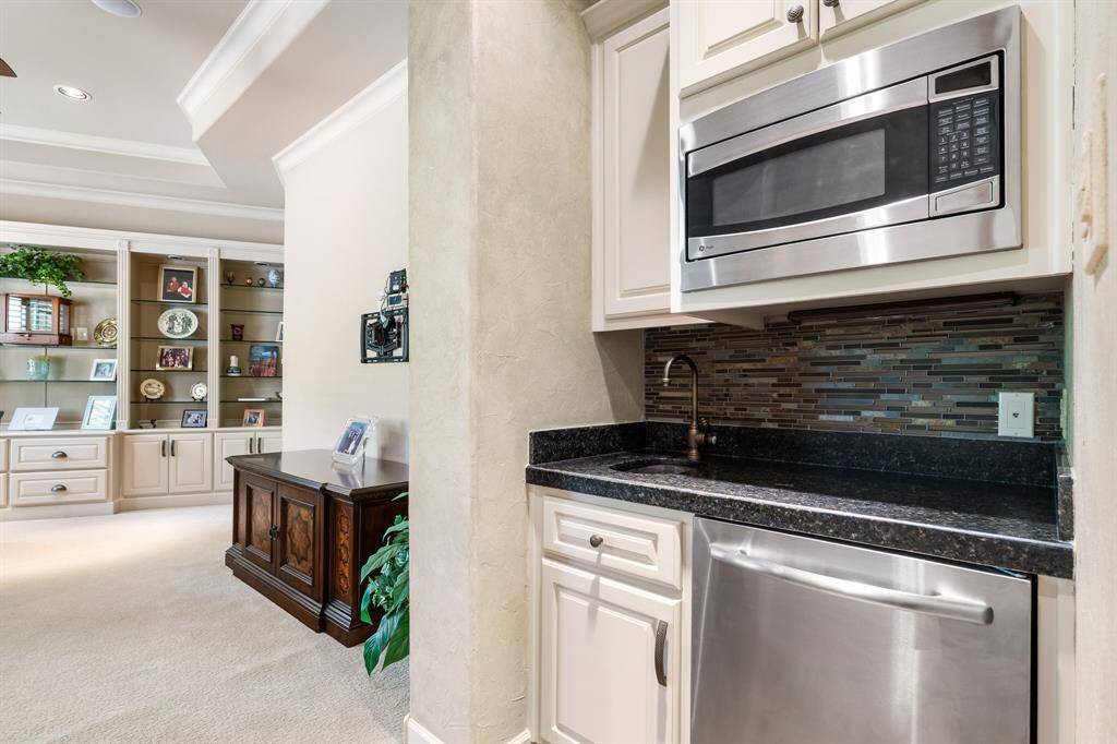 Upstairs, a second family room provides a comfortable retreat, complete with a convenient kitchenette featuring a microwave, mini fridge, and sink.