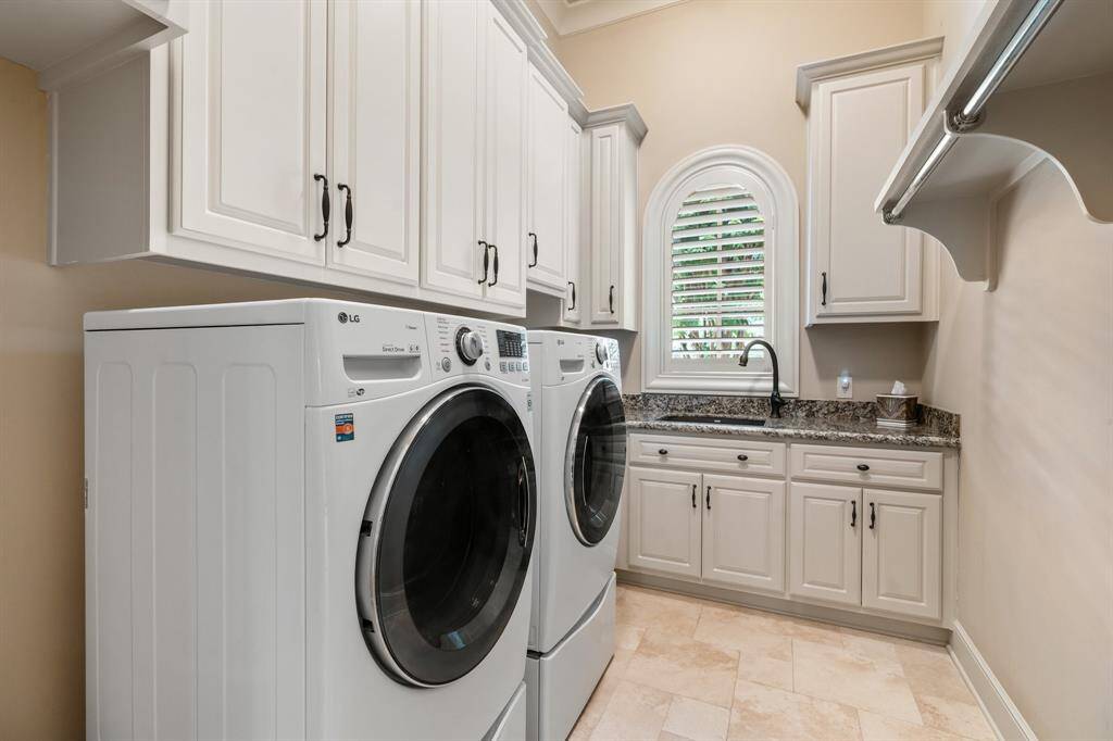 The home includes a spacious laundry room with ample counter space, storage cabinets, and room for full-size appliances, making everyday chores both convenient and efficient.