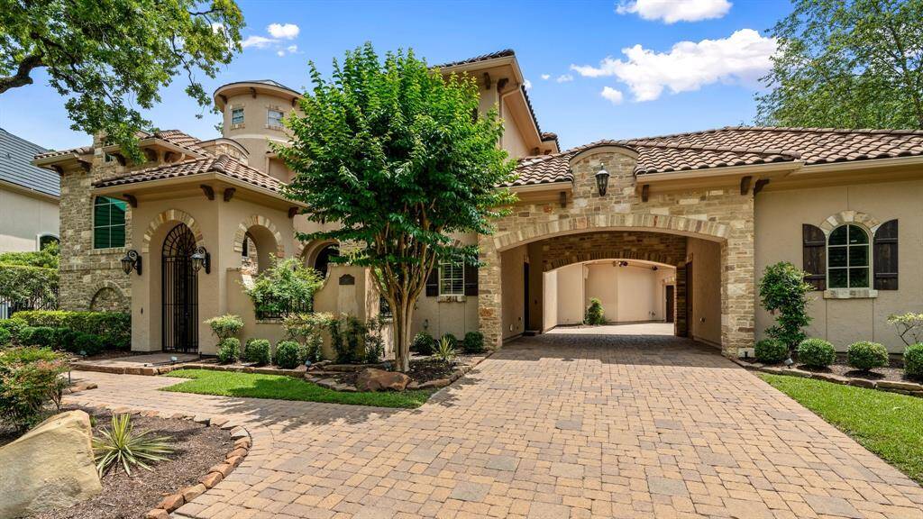 A classic cobblestone driveway adds charm to this inviting Mediterranean style home.  A spacious motor court in stamped concrete provides additional parking and play space.