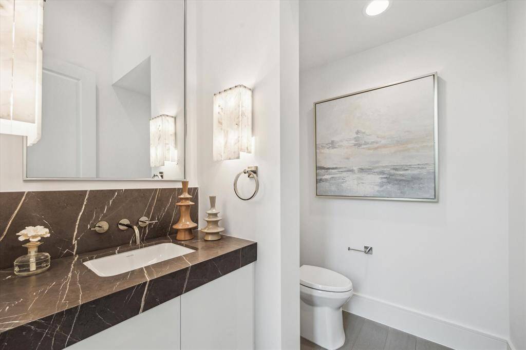 First floor powder features Leathered Piatra Gray Marble counter and backsplash, Kallista luxury fixtures and undermount sink, and additional storage.