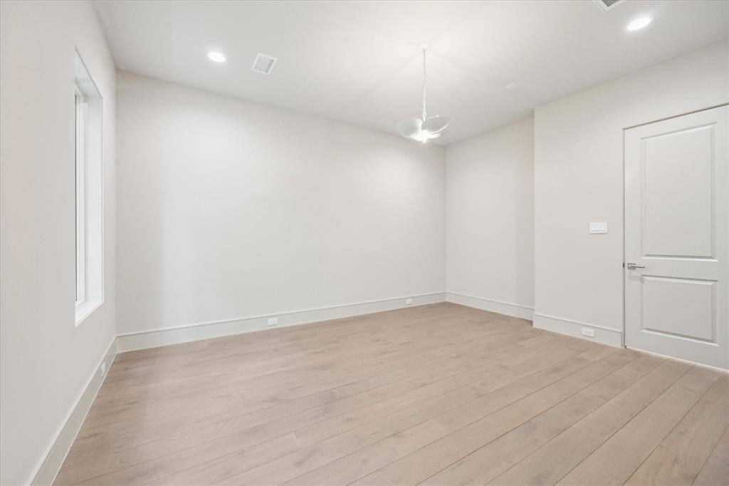The Primary Suite is adorned with 10-foot ceilings and a designer light fixture. Exquisite Legno Bastone European White Oak wood floors continue in this space adding to its overall elegance and charm. This home showcases one of the many upgrade options of 7" planks for the engineered wood floors that further elevate the space.