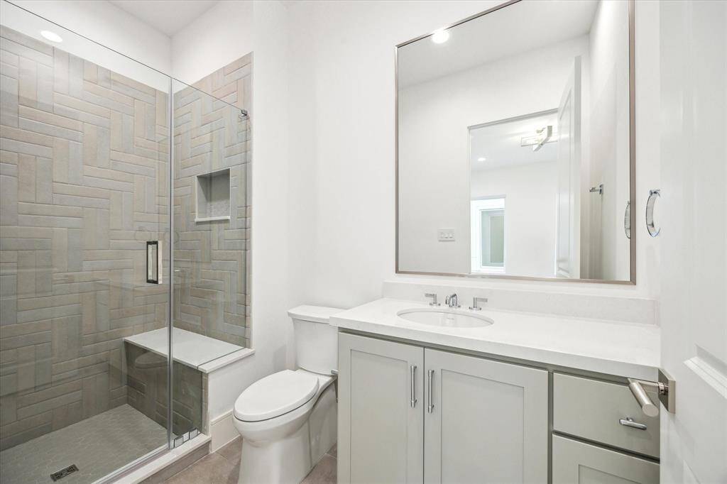 En-suite bathroom for final second-floor bathroom features a glass-enclosed freestanding shower with Quartz counters.