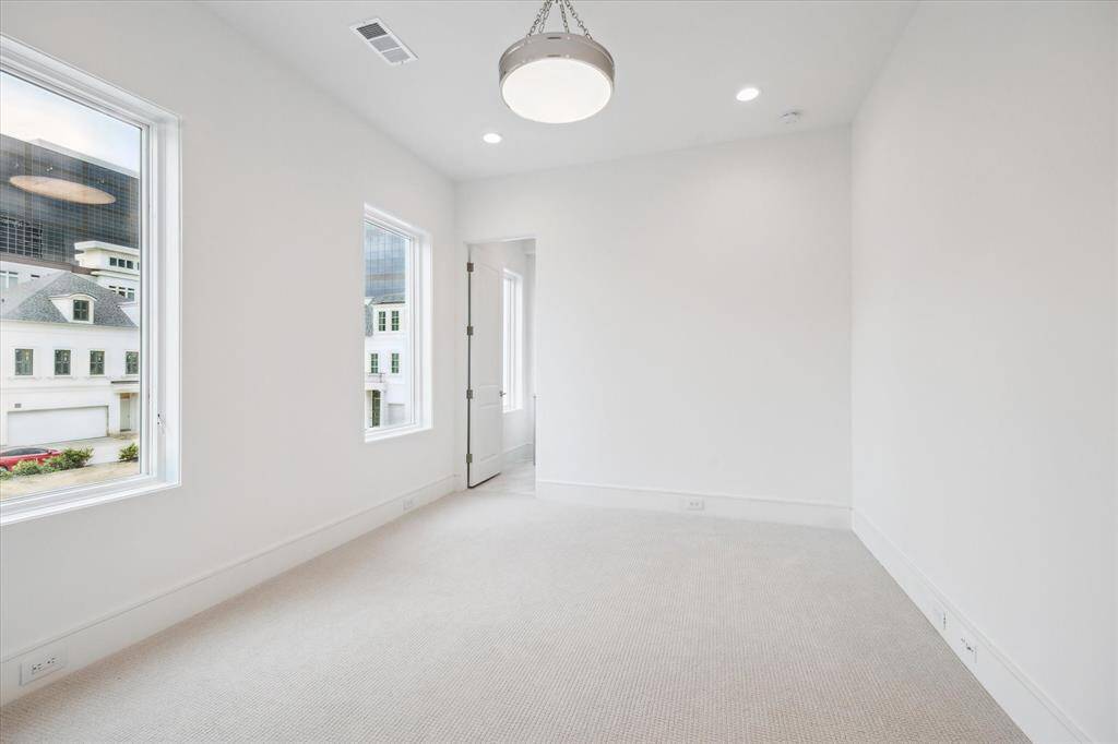 The final second-floor bedroom featuresShaw high-performance carpet from their Aerial Collection and Z-Lite semi flush-mount chandelier.