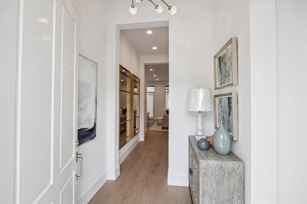 Step into this bright and welcoming formal entry. The first floor living space features 11-foot ceilings, Legno Bastone engineered White Oak wood floors, and designer light fixtures.