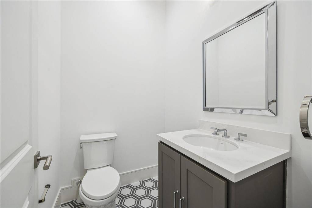 Conveniently located off of the third-floor flex space is a powder room featuring Biancone Quartz countertops and Adex hexagonal decorative floor tiles.