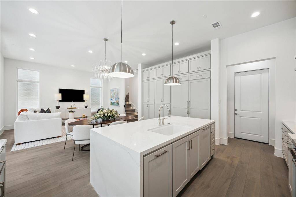 Polished Calcatta Gold Quartz waterfall island and undermount Porcelain sink with Kallista faucet complete this luxury kitchen. Ample prep space, storage space, and island seating make this space functional and stunning.