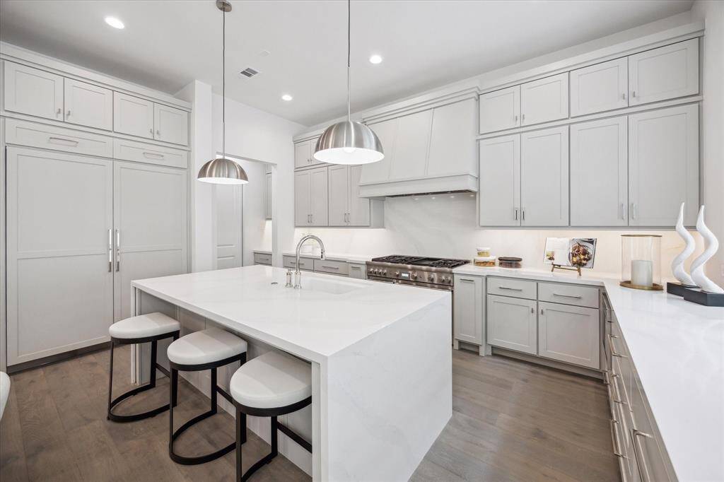 The kitchen showcases a premium Thermador appliance package, which includes a 48” Pro Harmony gas range, a 24” built-in MicroDrawer microwave, a 24” custom panel dishwasher, a 30” custom panel fresh food refrigerator, and 30” freezer columns.