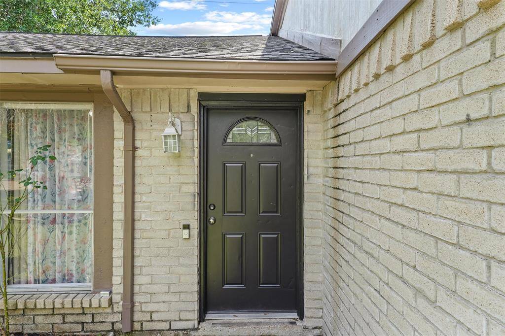 The rich espresso front door pops beautifully against the soft cream brick, while the taupe trim and muted rose accents create a cozy, grounded palette. This earthy color combo feels calm, classic, and instantly welcoming.