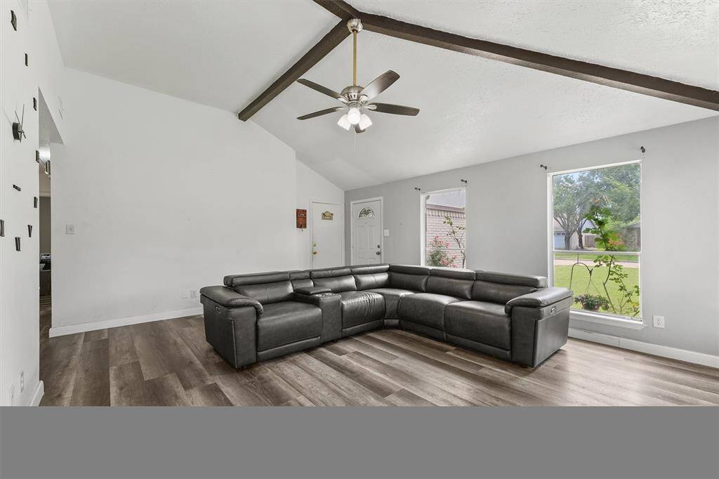 Sunlight streams in through oversized windows, bouncing off the vaulted ceiling and wrapping this cozy corner in calm. It’s more than a living room—it’s your new favorite spot.