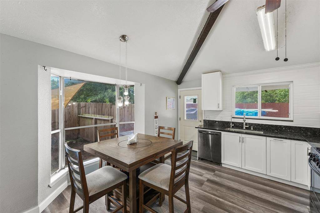 This bright dining nook offers a cozy space to start your day—with a perfect view of the custom outdoor dog area, designed with love for your furry companions to safely roam and relax.