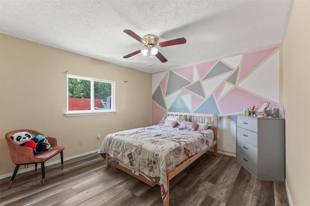Bright and inviting with playful accent walls and modern flooring, this cozy bedroom is perfect for kids, guests, or a creative space to make your own.