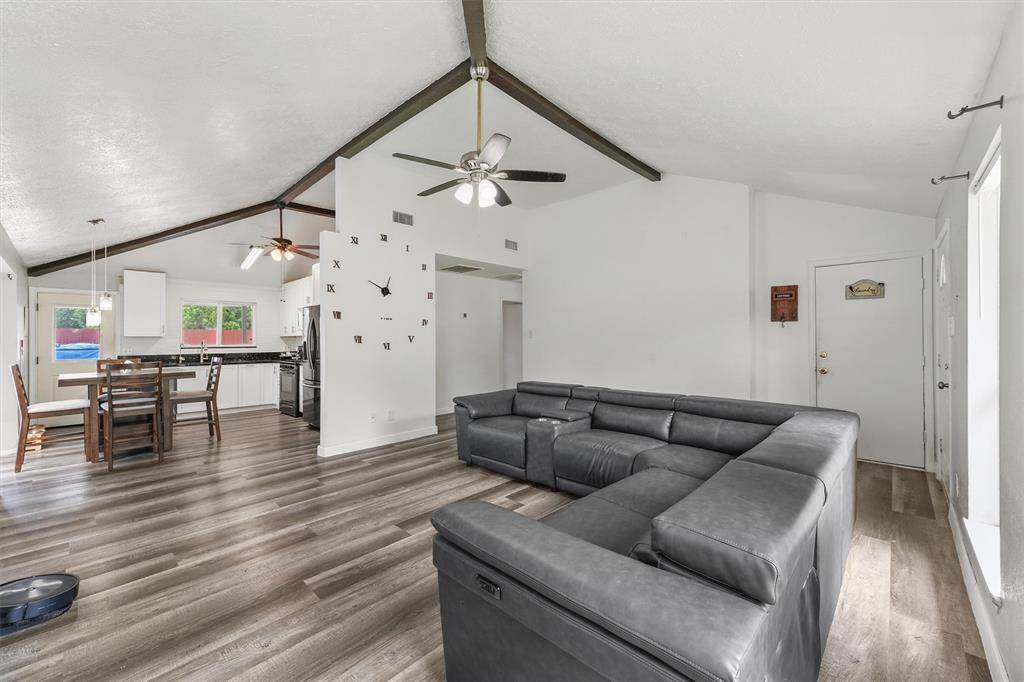 Vaulted ceilings, exposed beams, and seamless flow from the living room to the kitchen make this space feel wide open and wonderfully connected—perfect for everyday living and easy entertaining.
