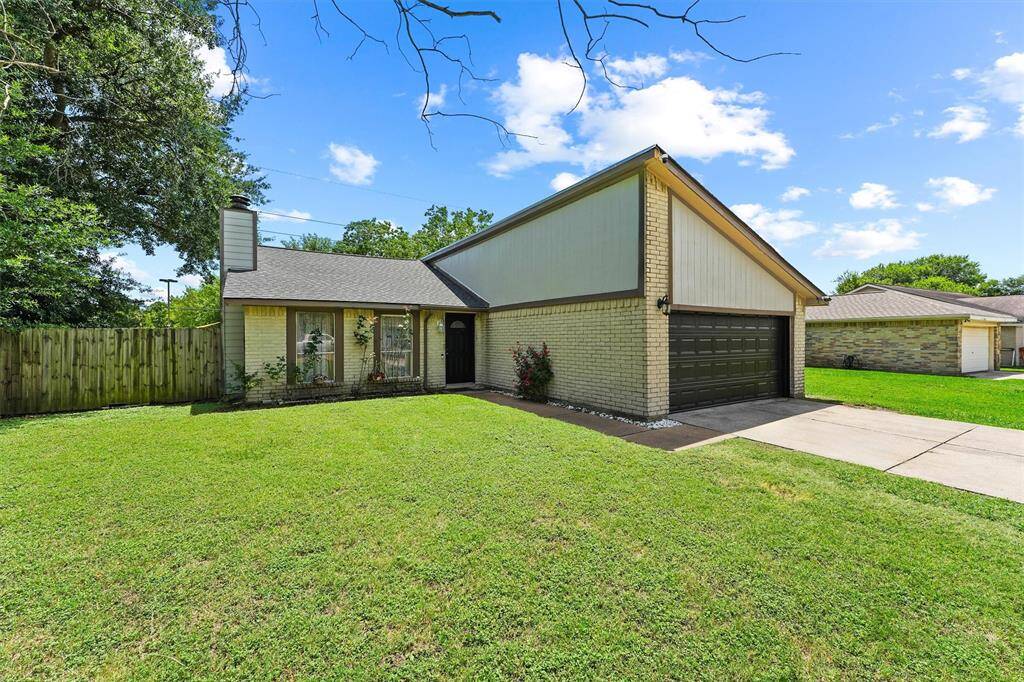 Set on a spacious corner of green, this home pairs classic brickwork with a bold trim finish and a hint of garden charm. With pops of color from the landscaping and a private fenced yard, it’s a peaceful retreat with personality.