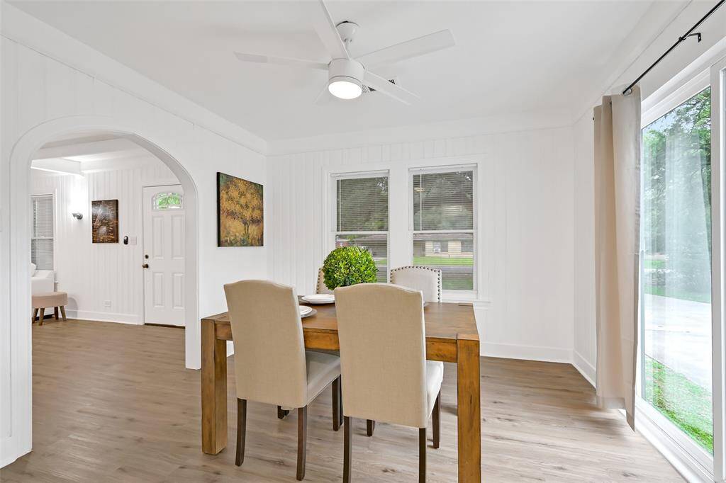 lovely arched wall to dining room with sliding glass door brings in natural light