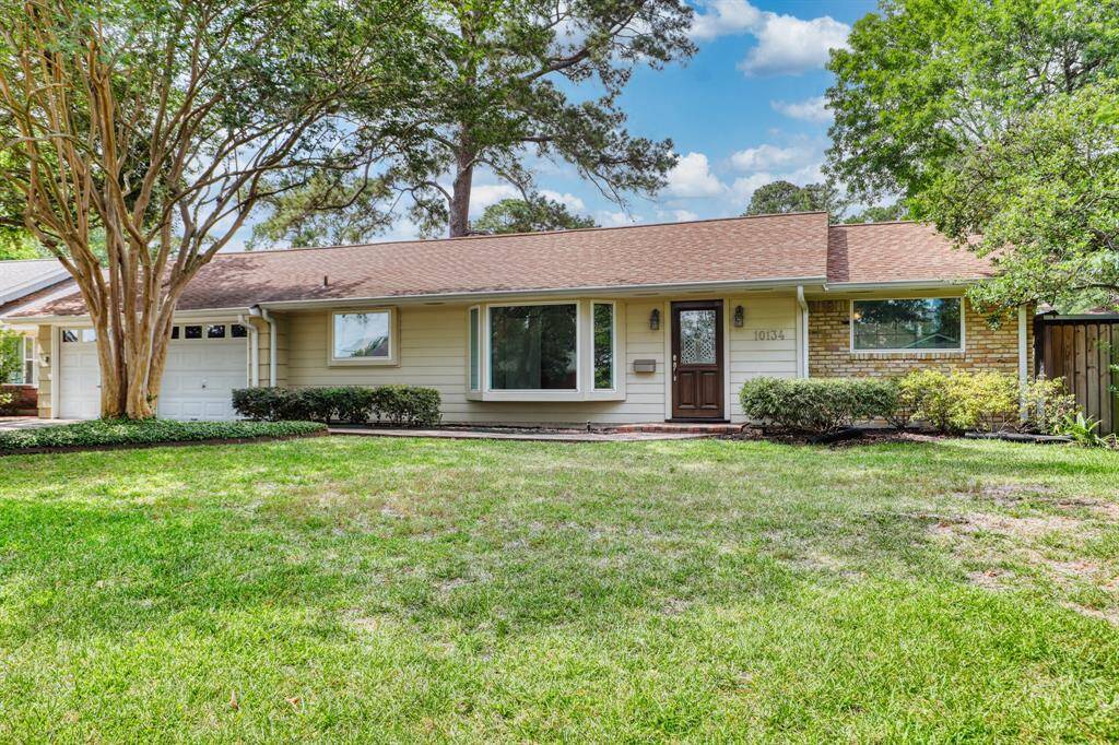 Featuring a welcoming front yard with well-maintained landscaping and mature trees. It has a classic exterior with a combination of brick and siding, and a cozy front porch. The attached garage and driveway offer convenient parking.
