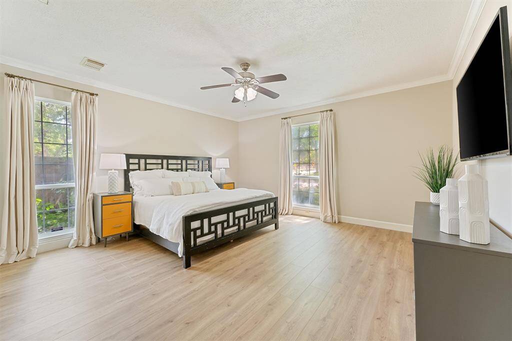 Bright, stylish, and functional, this home office features a large window with a modern light fixture and sleek flooring.
