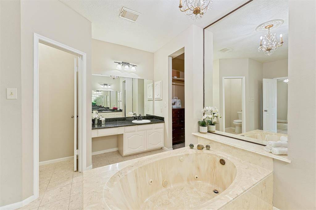If you’re looking for a spa-like experience at home, then this bathroom is for you. The spacious jacuzzi tub invites you to soak and relax. You can truly escape from the world. This modern bathroom is filled with details that elevate your experience. The luxurious marble finish of the bathtub blends seamlessly with the black counter tops and tiled floors. The large mirror is not only functional but it doubles as elegant home décor.