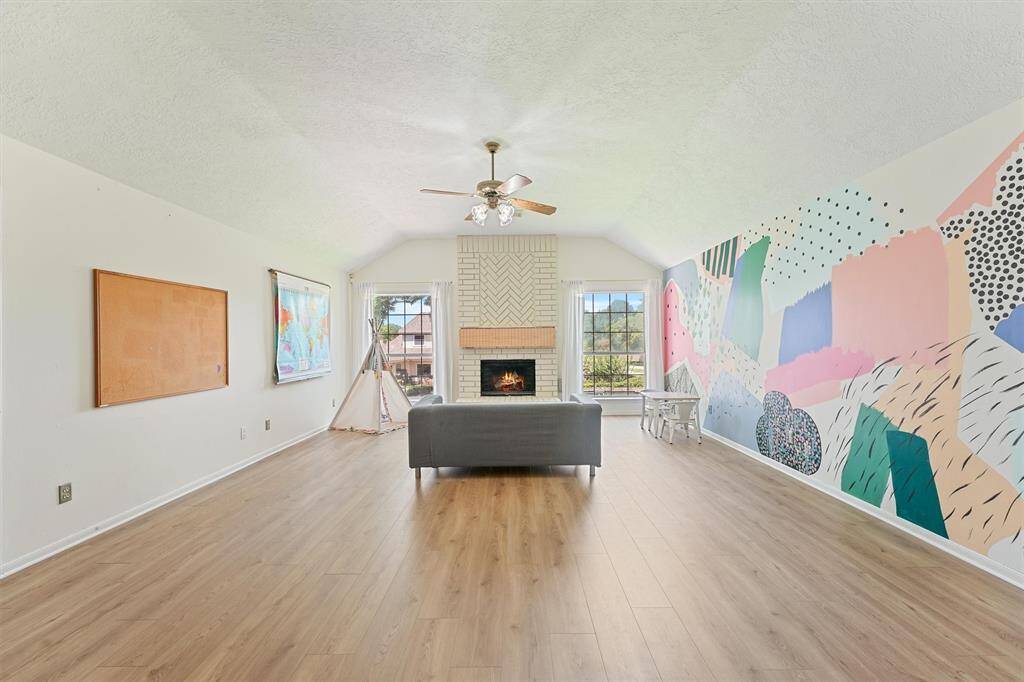 The warm feel of the flooring adds a natural look to the game toom, and the fireplace makes it feel like home and is large enough to accommodate your furniture needs and your guests. It has a spacious, high ceiling, so the room doesn't feel cramped. Additionally, it has a ceiling fan for comfort and there is a decorative mural that is sure to be a conversation starter.