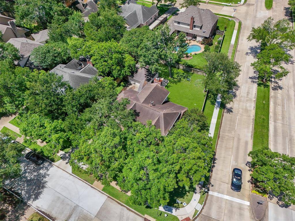 This two-story brick home offers generous, airy rooms, large windows, and high ceilings. It also has a spacious green lawn and a detached garage. The property is surrounded by lush trees, which offer a peaceful, private setting. This two-story brick house is the perfect dream home for your family.