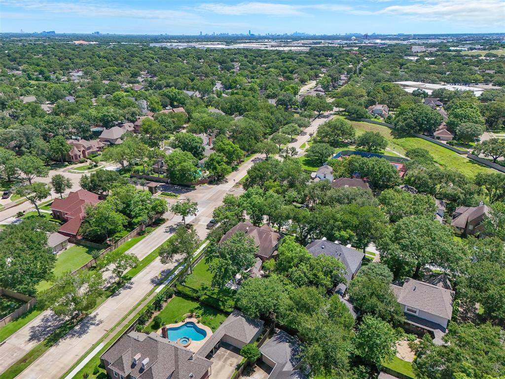 Take a closer look at the neighborhood with lush greenery, tree-lined streets, and spacious homes. The area appears peaceful and well-maintained, offering a serene environment for potential buyers.