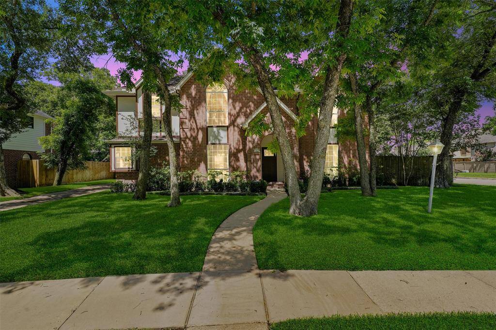 Set amidst mature trees, a well-maintained lawn and a curved walkway leads to the entrance, creating a welcoming front yard.