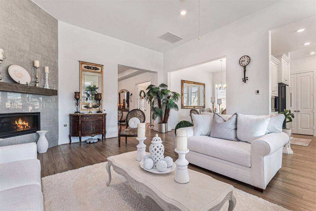 Open living room with a cozy fireplace, abundant natural light, and seamless flow to the dining area. Perfect for relaxation and entertaining.