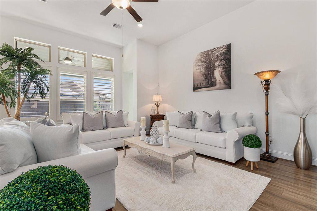 Bright and inviting living room with ample natural light, elegant decor, and a cozy seating area for relaxation.