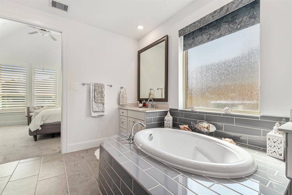 Indulge in the elegance of this primary bathroom, featuring a luxurious soaking tub and abundant natural light.