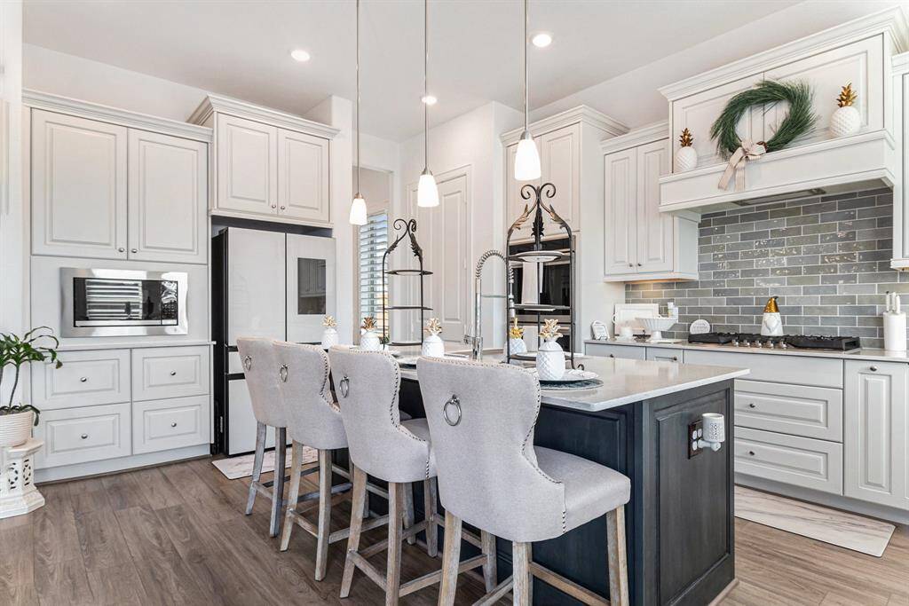 Elegant kitchen features modern cabinetry, a spacious island with seating, and high-end appliances, perfect for cooking and entertaining.