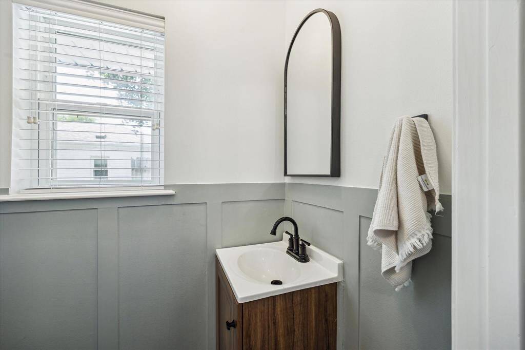 Updated 1/2 bathroom with a half-wall wainscoting design.