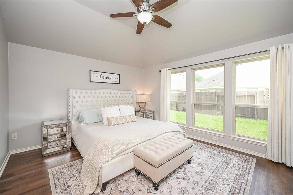 The primary suite boasts tall coffered ceilings and stunning wall of floor-to-ceiling windows overlooking the back yard.